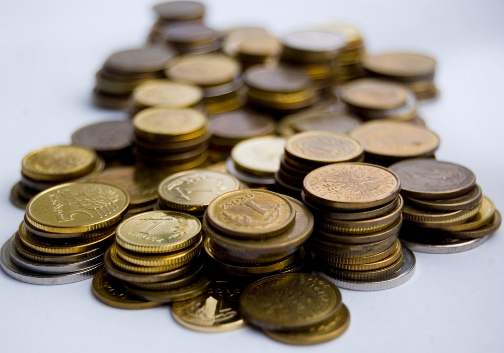 Stacks of gold and silver coins representing precious metals markets reacting to Fed Chair Kevin Warsh's inflation-focused policy outlook