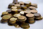 Stacks of gold and silver coins representing precious metals markets reacting to Fed Chair Kevin Warsh's inflation-focused policy outlook